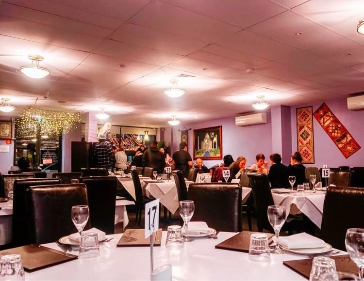 Kohinoor's dining room with lilac walls and traditional wall hangings